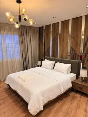 a bedroom with a large white bed and a chandelier at Suite Bahiya 15 in Fès