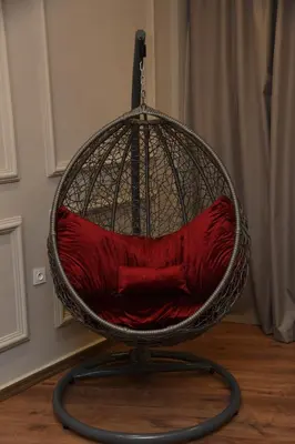 a basket chair with a red pillow in a room at Suite Bahiya 15 in Fès