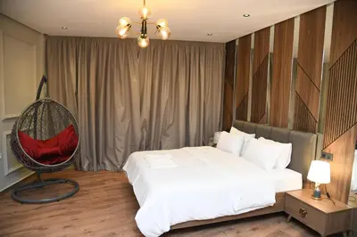 a bedroom with a white bed and a chair at Suite Bahiya 15 in Fès