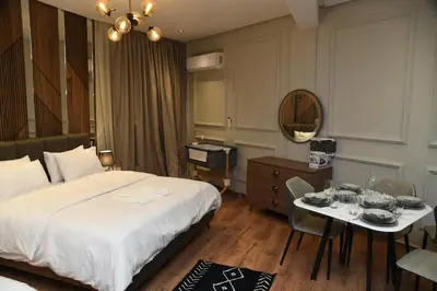 a hotel room with a bed and a table and a mirror at Suite Bahiya 15 in Fès