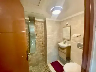 a bathroom with a sink and a toilet and a mirror at Rare, duplex 3 chambres, proche du centre in Oulad Akkou