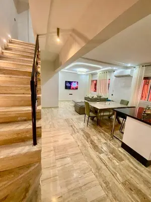 a living room with a staircase and a table at Rare, duplex 3 chambres, proche du centre in Oulad Akkou
