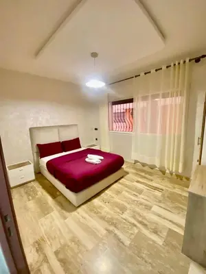 a bedroom with a bed with red sheets and a window at Rare, duplex 3 chambres, proche du centre in Oulad Akkou