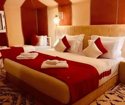 a hotel room with a large bed with towels on it at Starvile Luxury Camp in Merzouga