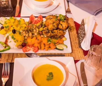 a plate of food on a table with a bowl of soup at Starvile Luxury Camp in Merzouga