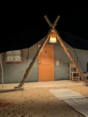 an entrance to a house with an orange door at Lunanir lodge Camp in Hassilabied