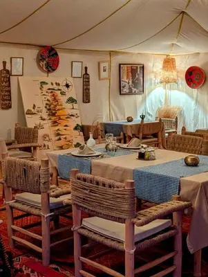 a dining room with a table and chairs in a tent at Lunanir lodge Camp in Hassilabied