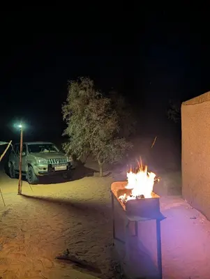 a car parked in front of a fire pit at night at Lunanir lodge Camp in Hassilabied