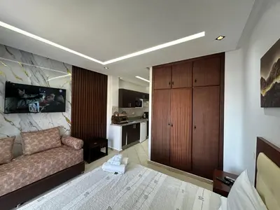 a living room with a couch and a kitchen at Studio Appart hotel in Oulad Akkou