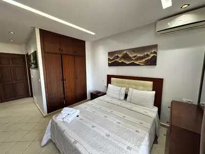 a bedroom with a large bed and a wooden cabinet at Studio Appart hotel in Oulad Akkou