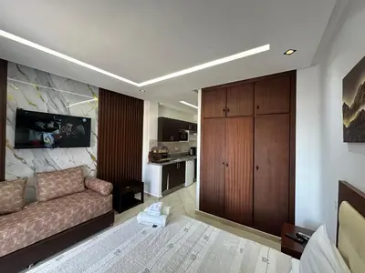 a living room with a couch and a kitchen at Studio Appart hotel in Oulad Akkou