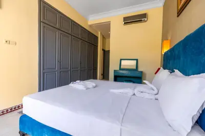 a bedroom with a large white bed with towels on it at Malaya Majestic in Srarhna
