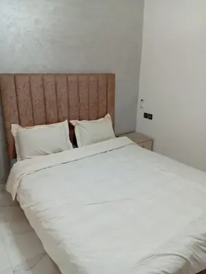 a large white bed with white sheets and pillows at Appartement29 in Fès