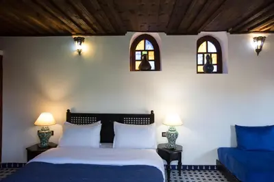 a bedroom with a bed and two windows at Riad Ruh Fes in Fès