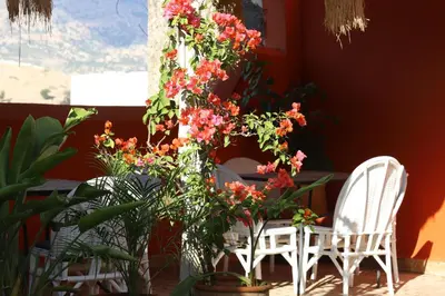 a table with two white chairs and flowers at Riad Ruh Fes in Fès