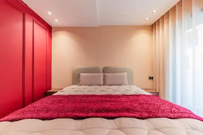 a bedroom with a large bed with red walls at Luxury Suite des Princesses in Oulad Akkou
