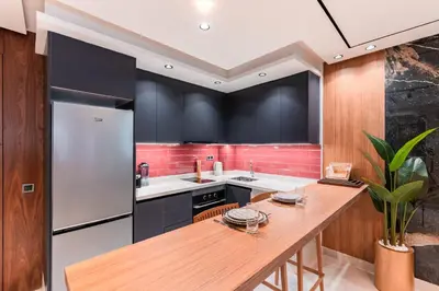 a kitchen with black cabinets and a wooden counter top at Luxury Suite des Princesses in Oulad Akkou