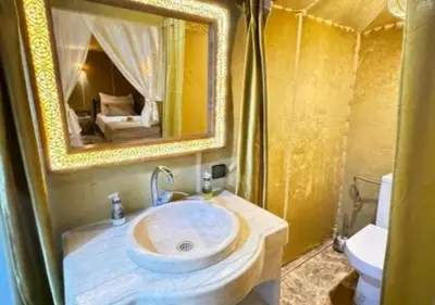 a bathroom with a sink and a mirror at Camp Lovers Desert in Merzouga