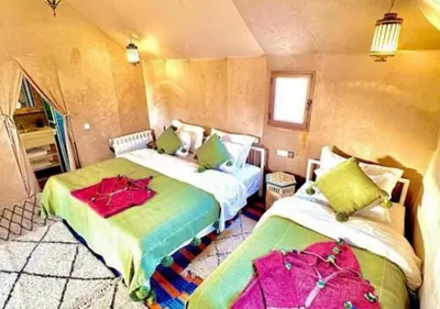 a bedroom with two beds in a room at Camp Lovers Desert in Merzouga