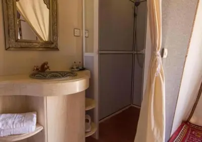 a bathroom with a sink and a refrigerator at Camp Lovers Desert in Merzouga