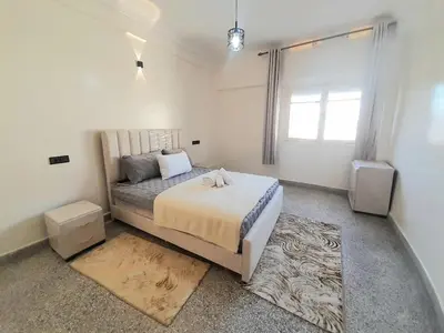 a bedroom with a large bed and two speakers at City Center Apartment Fez in Fès