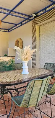 a table with chairs and a vase on it at Villa Nafsi Aghmat Marrakech Piscine Chauffée in Aït Namous