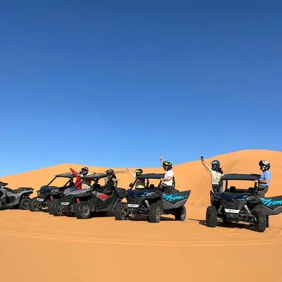 a group of people riding atvs in the desert at Merzouga whisper camp in Merzouga