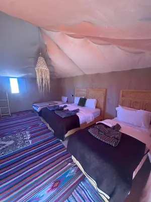 a room with three beds in a tent at Luxury camp in Hassilabied