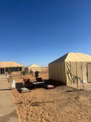 a tent and a bench in the middle of the desert at Luxury camp in Hassilabied