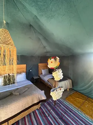 a room with two beds in a tent at Luxury camp in Hassilabied