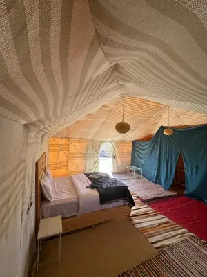 a bedroom with a bed in a tent at Luxury camp in Hassilabied