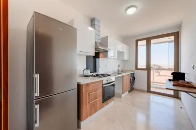 a kitchen with a large stainless steel refrigerator at Azur Apartment pool & design in Oulad Akkou