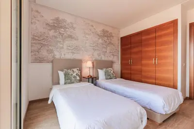 two beds in a small room with wooden cabinets at Azur Apartment pool & design in Oulad Akkou