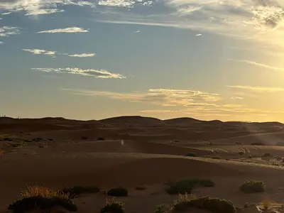 a view of the desert at sunset at LUNA LLENA Desert Camp Merzouga in Merzouga