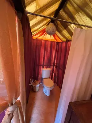 a bathroom with a toilet in a tent at LUNA LLENA Desert Camp Merzouga in Merzouga