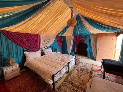 a bedroom with a bed with a canopy at LUNA LLENA Desert Camp Merzouga in Merzouga