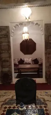 a living room with a bench and a chandelier at IVANKA Guest House in Fès