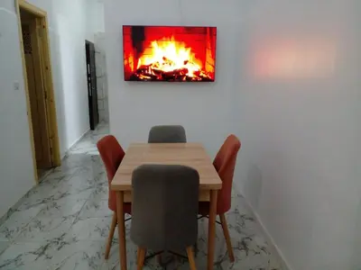 a dining room table with a fire painting on the wall at Casa Miriam fes in Fès