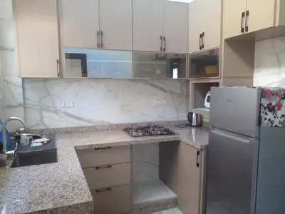 a kitchen with white cabinets and a refrigerator at Casa Miriam fes in Fès