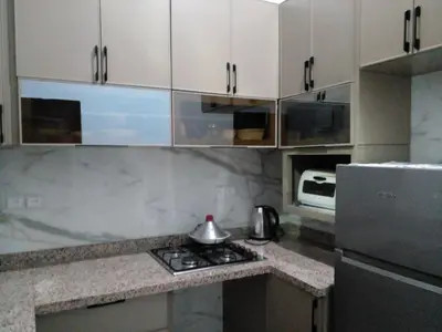 a kitchen with white cabinets and a tea kettle on a stove at Casa Miriam fes in Fès