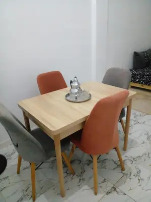 a wooden table with four chairs and a tea kettle on it at Casa Miriam fes in Fès