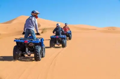 a group of people riding atvs in the desert at Gite Omar merzouga in Merzouga