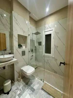 a bathroom with a shower and a toilet and a sink at Exceptional Marrakech Villa 5 Bedrooms & Pool in Oulad Akkou