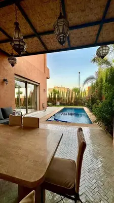 a patio with a table and a swimming pool at Exceptional Marrakech Villa 5 Bedrooms & Pool in Oulad Akkou