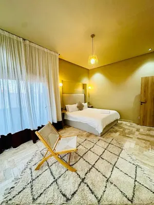 a bedroom with a bed and a chair in it at Exceptional Marrakech Villa 5 Bedrooms & Pool in Oulad Akkou
