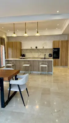 a kitchen with a table and chairs and a counter at Exceptional Marrakech Villa 5 Bedrooms & Pool in Oulad Akkou