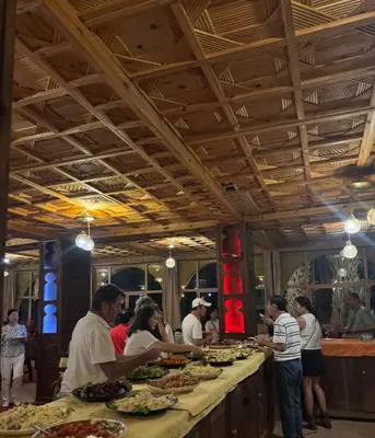 a group of people standing around a buffet line with food at Ksar merzouga luxury camp in Merzouga