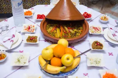 a table with a bowl of fruit and a bowl of food at Riad Dalia - Fes Medina in Fès