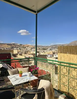 a balcony with a table and a view of a city at Riad Dalia - Fes Medina in Fès