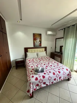 a bedroom with a bed with a red flowered blanket at BEST DREAM Spot in Oulad Akkou